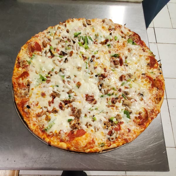 A large, freshly baked Dough Boys Pizzeria pizza with pepperoni, sausage, mushrooms, and green peppers.
